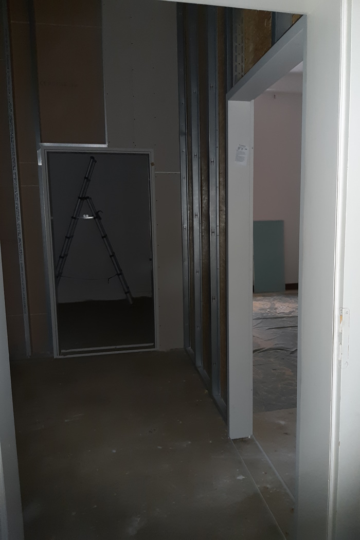 Aus einem Raum wurden zwei: Blick in das zukünftige barrirefreie WC noch ohne Einbauten (Leiter) und das entstehende Backoffice.