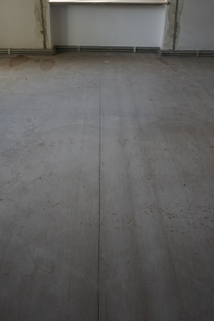 Auf der Meterware des PVCs zeichnen sich die darunter liegenden Hozldielen des bauzeitlichen Fußbodens ab.